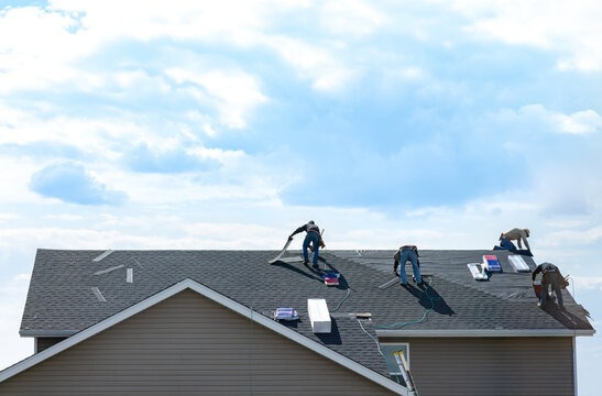 HomeFirst Roofing crew actively laying shingles
